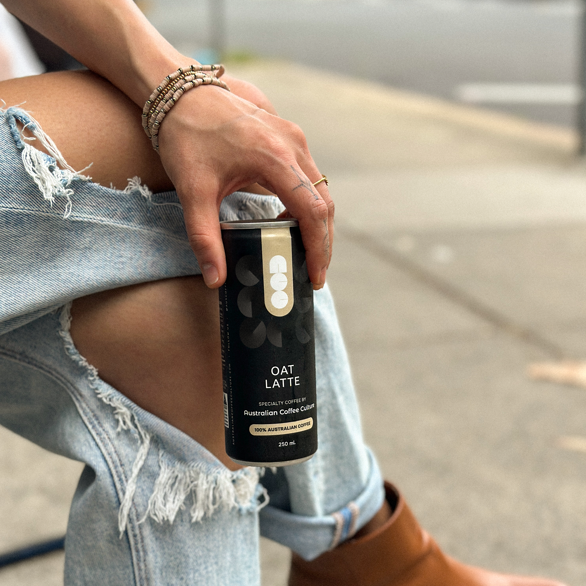 Person holding a can of 'Oat Latte'.