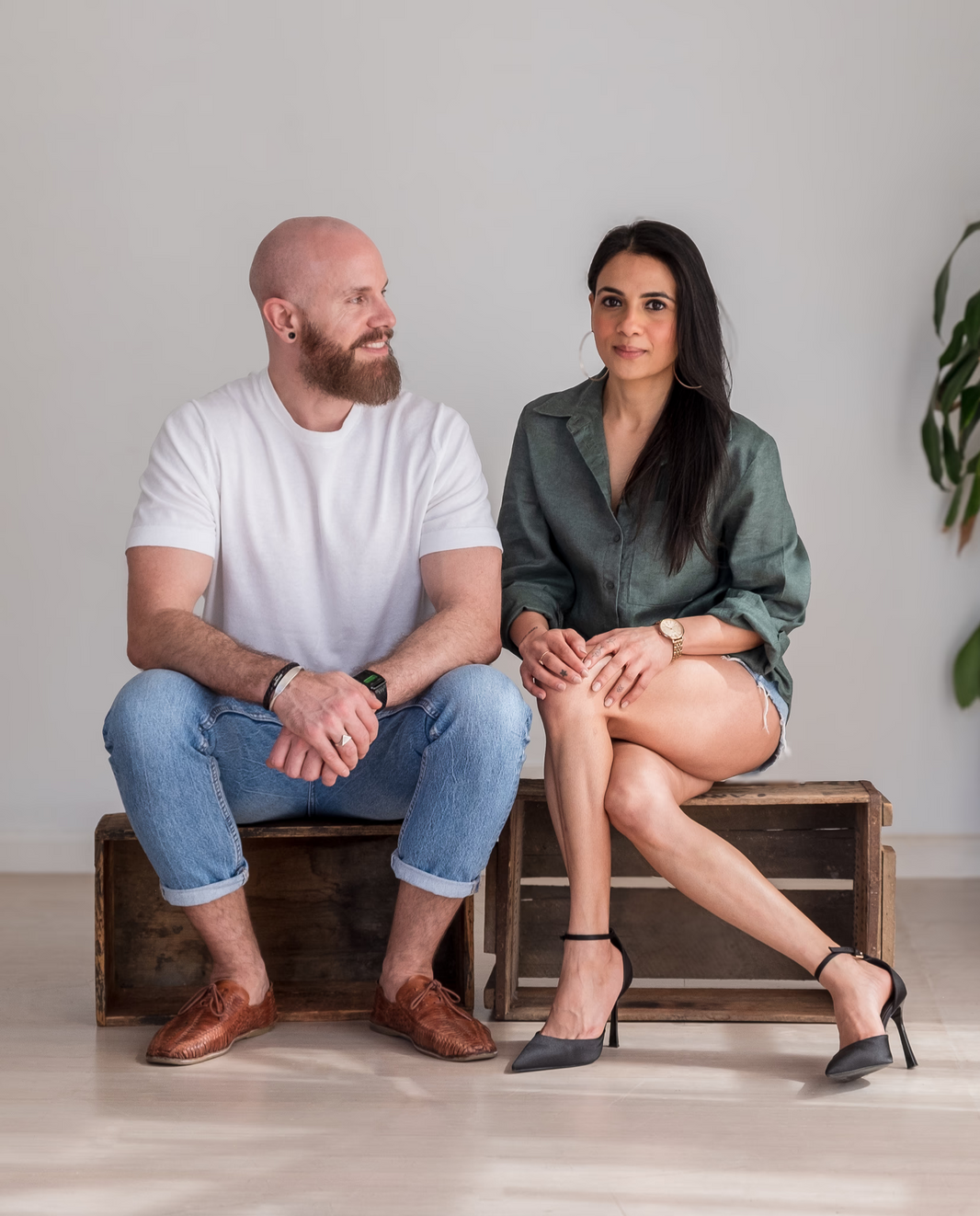 Man and woman, founders of Bjorn, sitting on a wooden box against a plain background