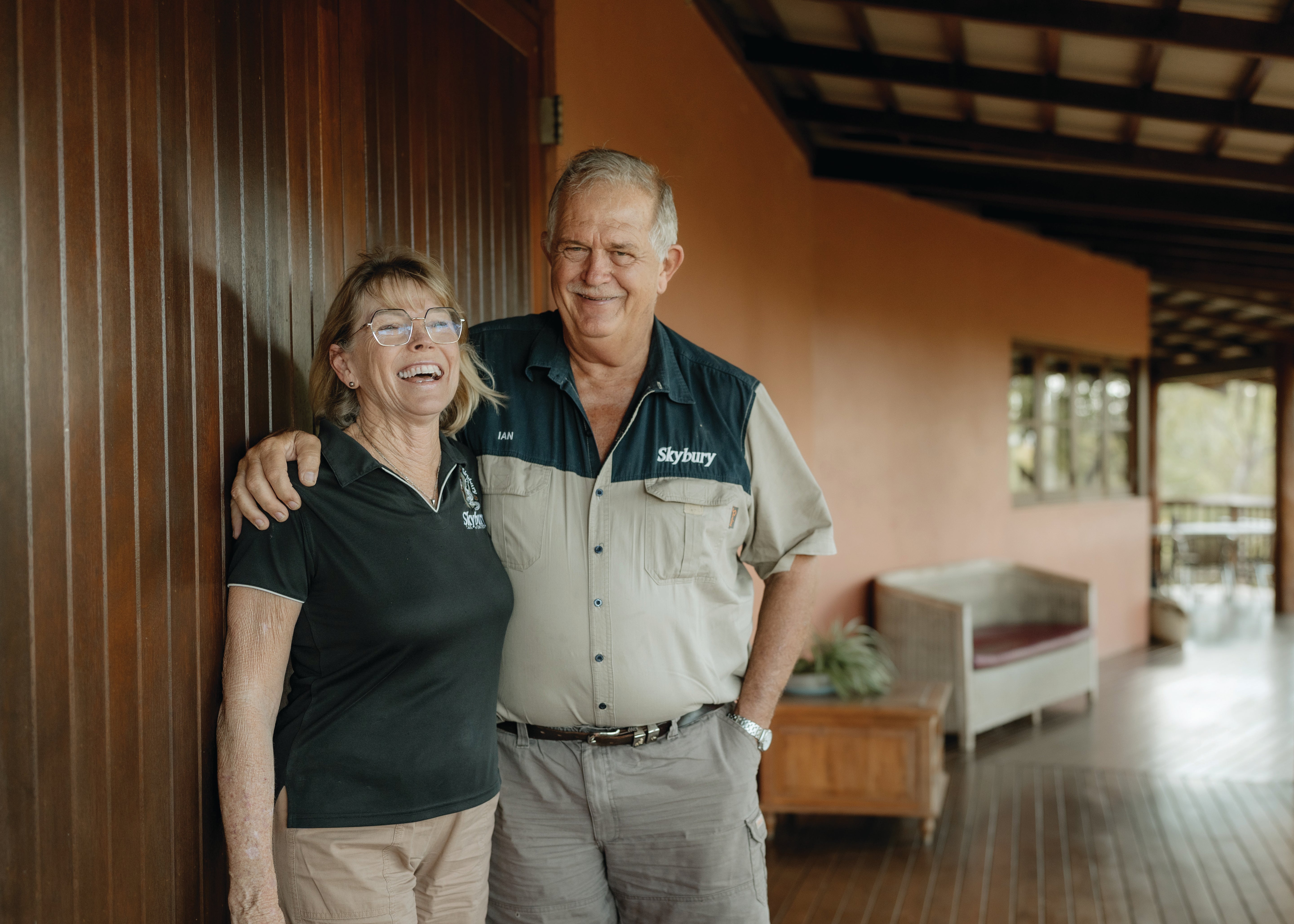 The owners of Skybury standing together in an outdoor setting with a building in the background